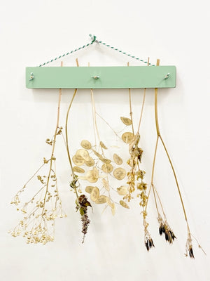 Flower drying kit by Studio wald in use with flowers attached hanging on a wall