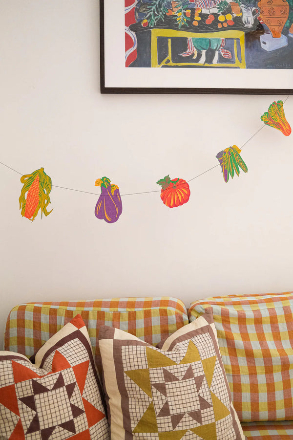 East End Press Vegetable garland hanging on wall above a sofa