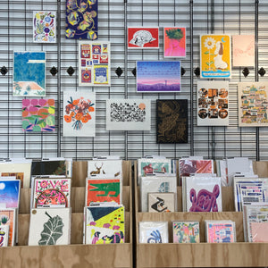 Image of the gallery print wall of Form Shop & studio in Hull featuring lots of colourful images of art prints and racks of prints for browsing. 