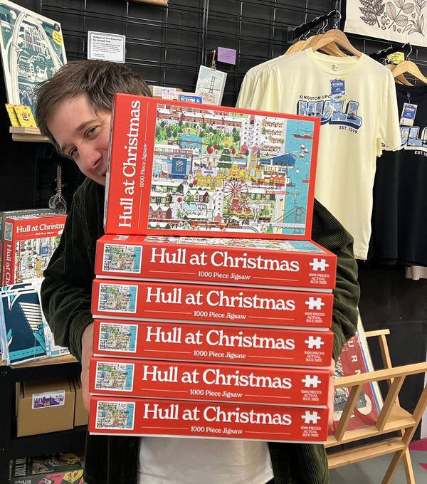 Joseph Cox holding a stack of Hull at Christmas jigsaws