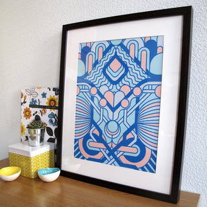 Framed geometric art print with blue and pink in a black frame 