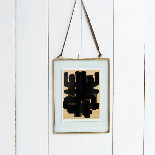 Contemporary art print in a brass hanging glass frame